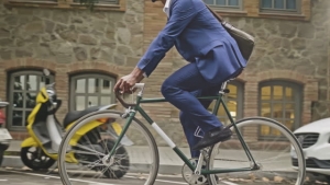 Mid-section slow motion video of businessman riding a bicycle in the city.